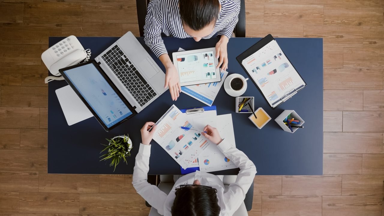 top-view-of-business-women-comparing-financial-graphs-with-management-statistics-expertise.jpg